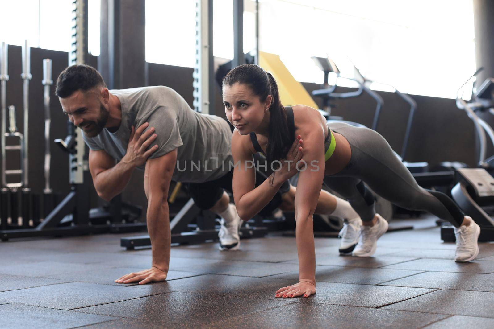 Portrait of beautiful young sports couple on a plank position