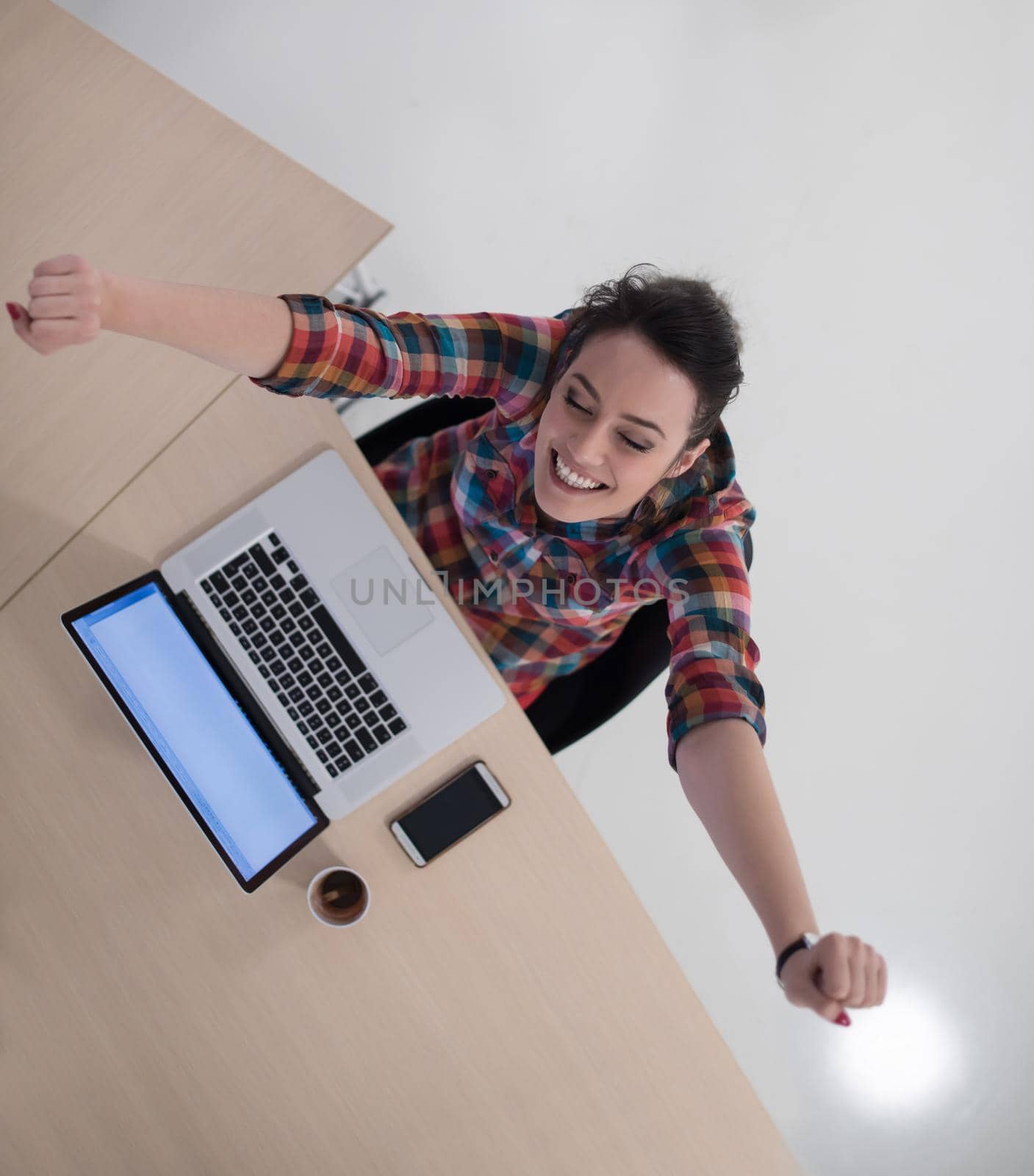 top view of young business woman working on laptop computer in modern bright startup office interior