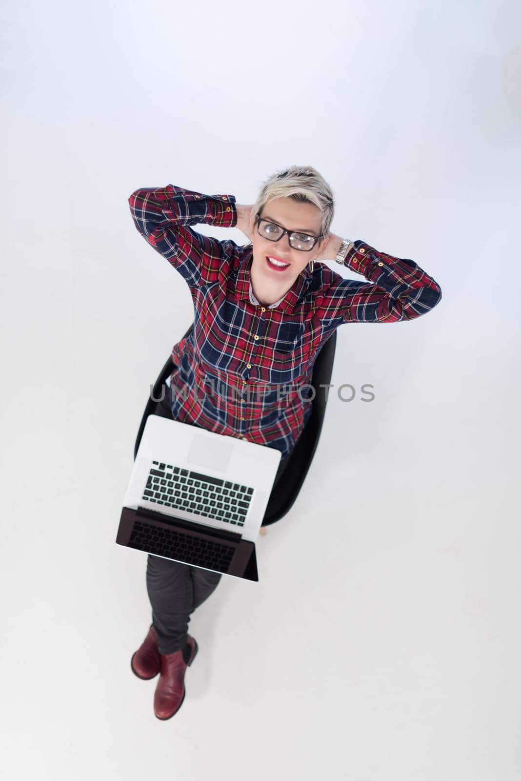 top view of young business woman working on laptop computer in modern bright startup office interior, sitting on floor