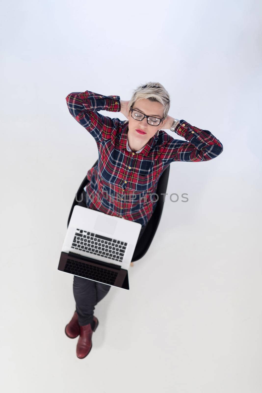 top view of young business woman working on laptop computer in modern bright startup office interior, sitting on floor