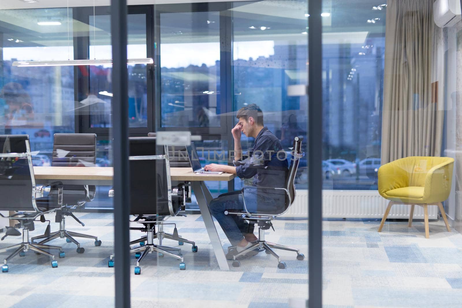 A time for relax. Young tired casual businessman relaxing at the desk in his office