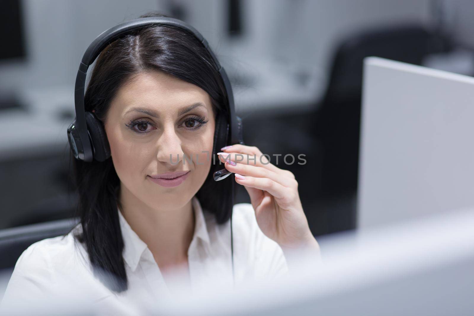 young smiling female call centre operator doing her job with a headset