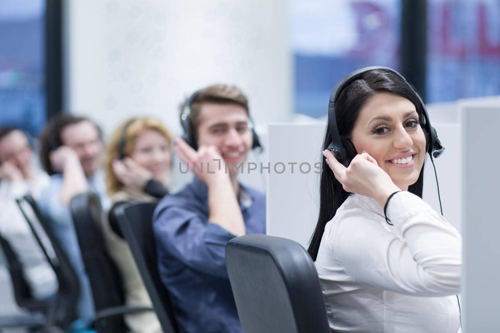 group of young business people with headset working and giving support to customers in a call center office