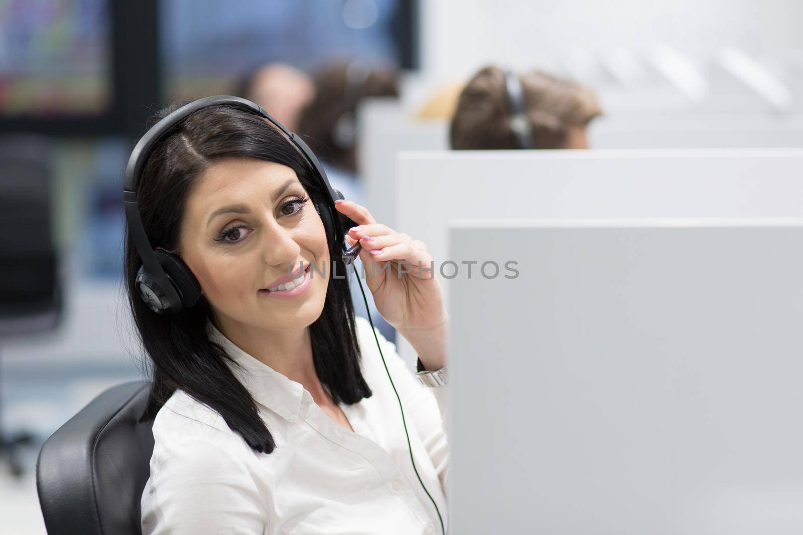 young smiling female call centre operator doing her job with a headset