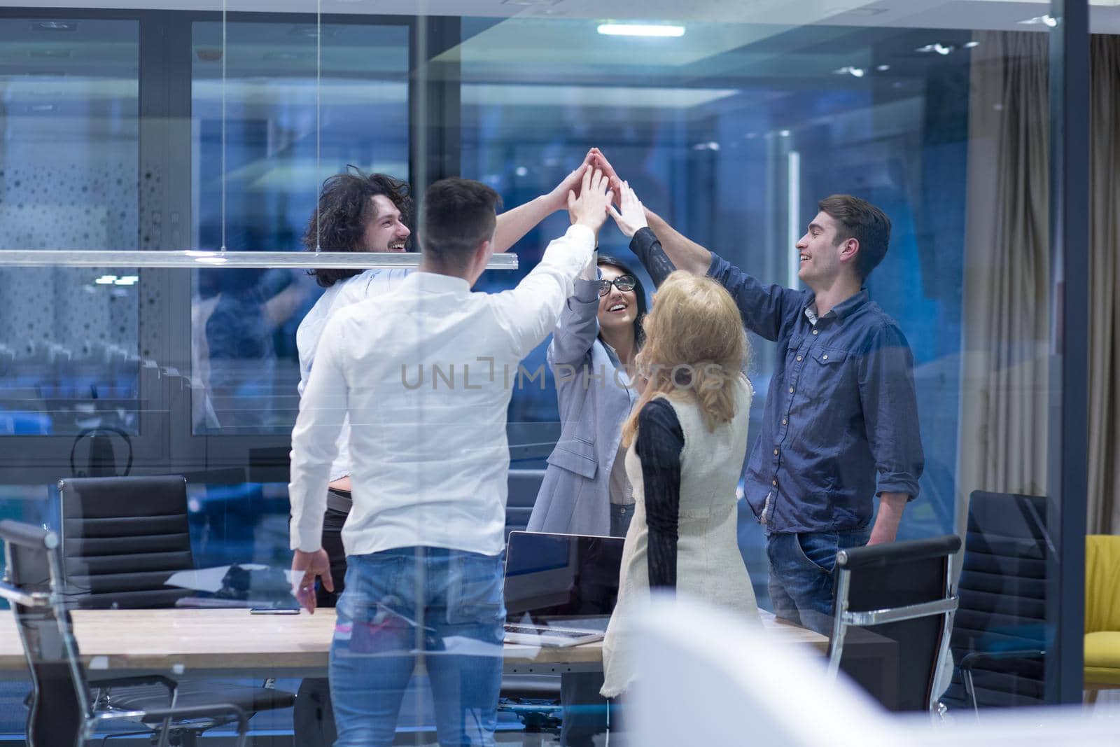 Group of young business people looking happy while celebrating success at their working places in startup office