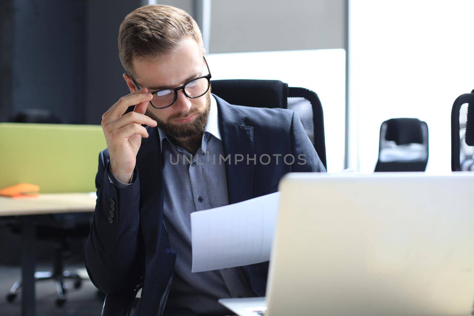 Young man is working with papers while sitting in the office