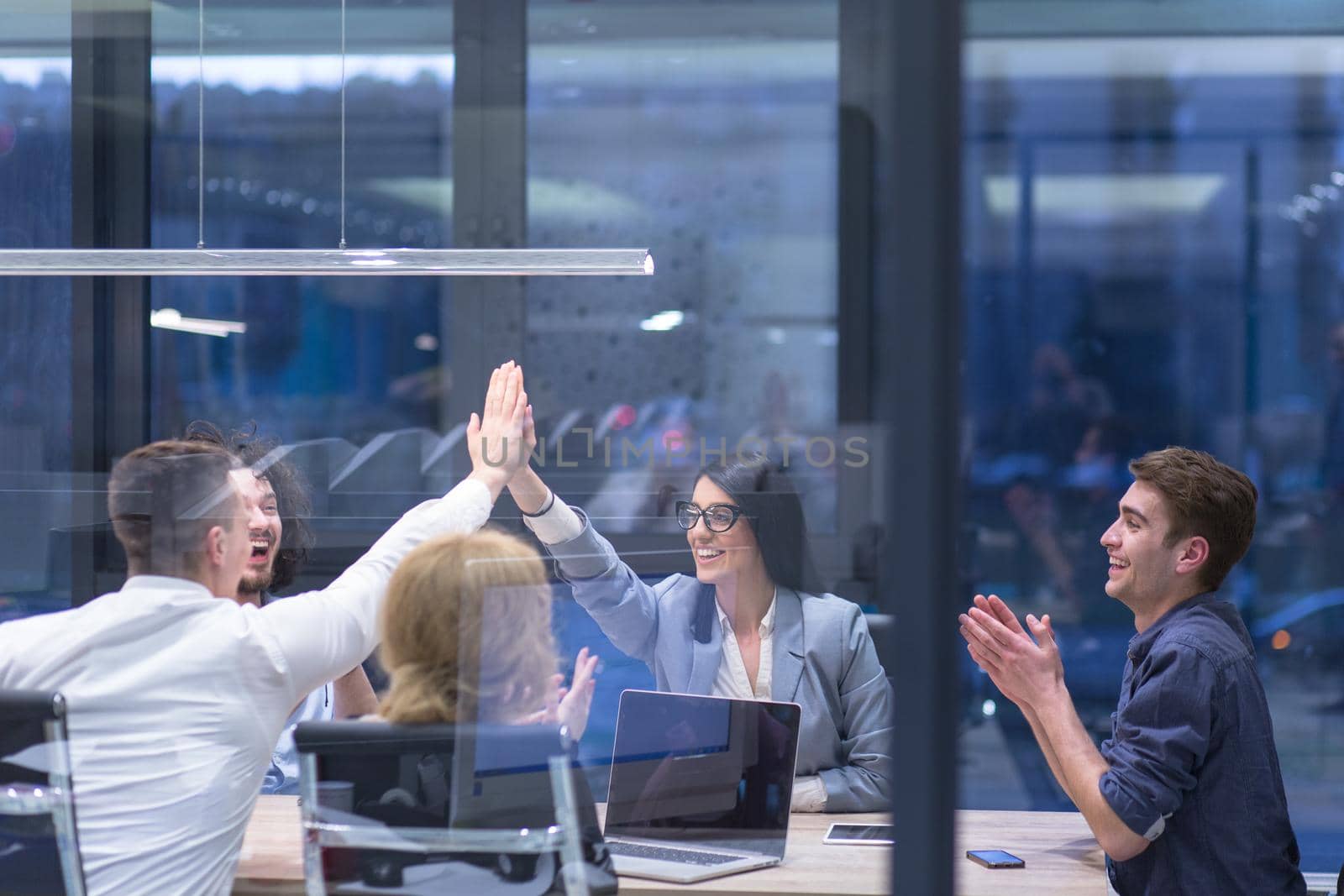 Group of young business people looking happy while celebrating success at their working places in startup office