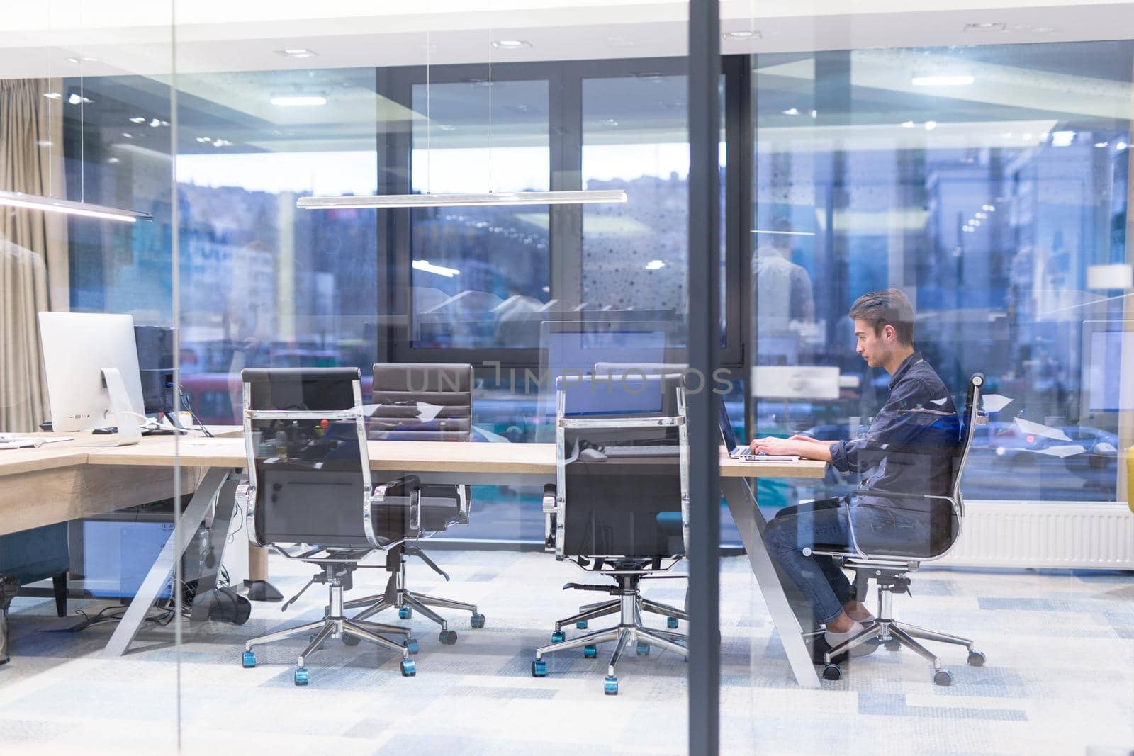 A time for relax. Young tired casual businessman relaxing at the desk in his office