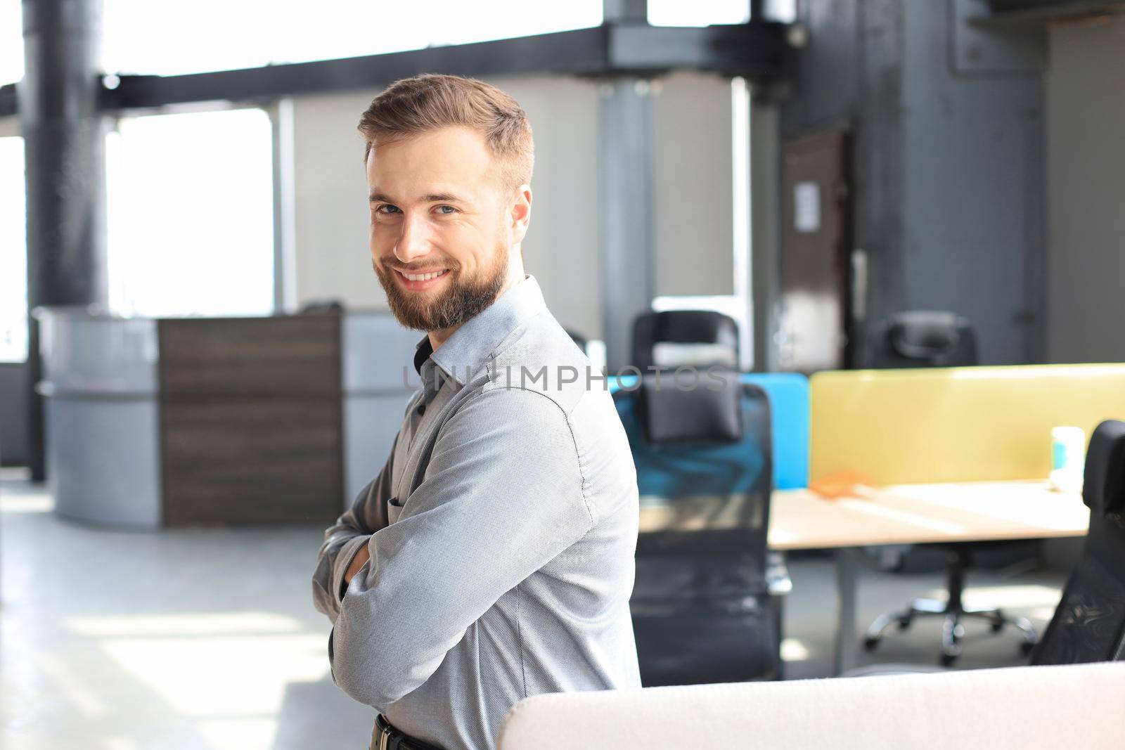 Young handsome businessman smiling in an office environment. by tsyhun