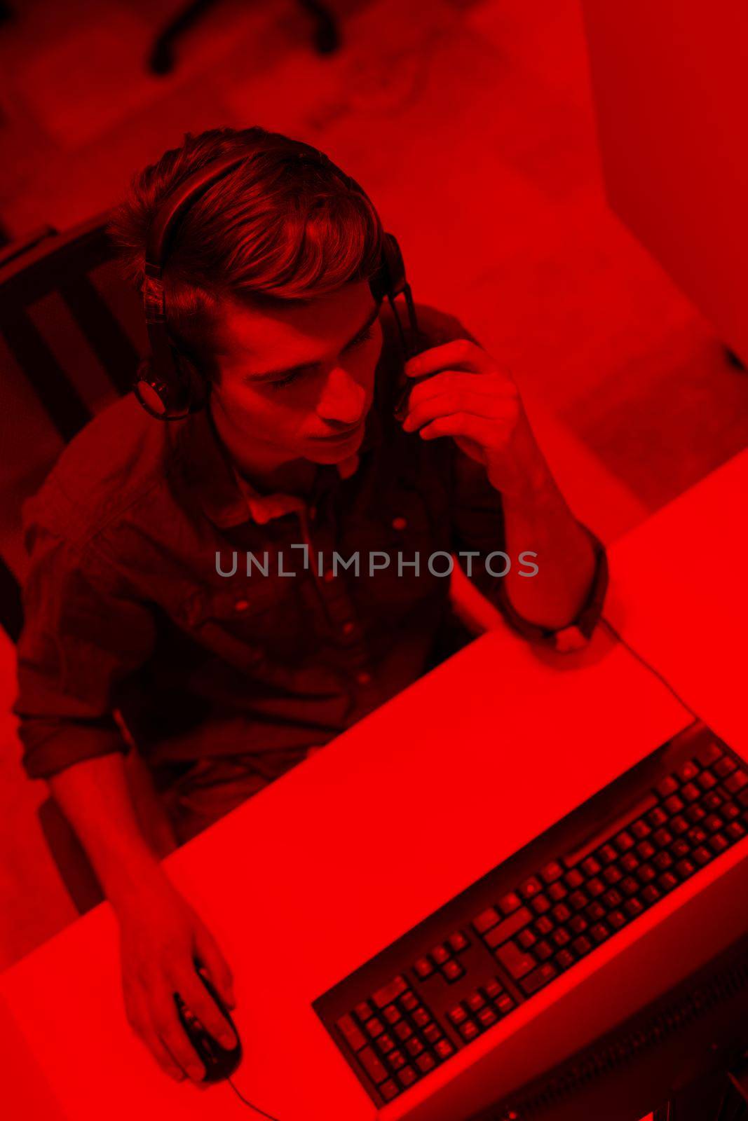 top view of a young smiling male call centre operator doing his job with a headset