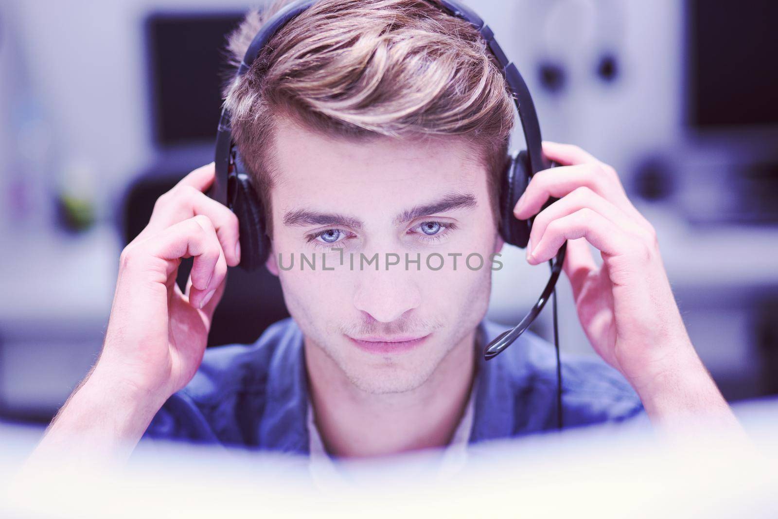 young smiling male call centre operator doing his job with a headset