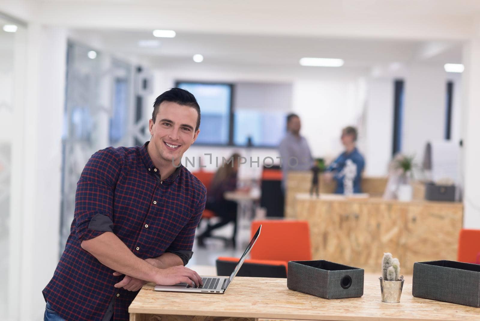 portrait of young businessman in casual clothes at modern  startup business office space,  working on laptop  computer