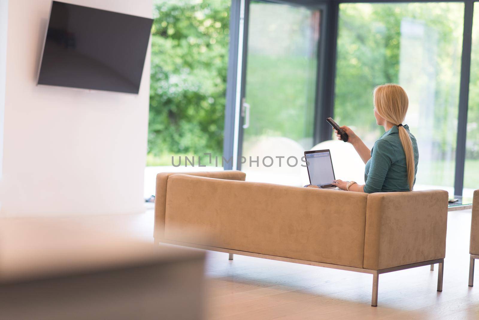 Young woman using her laptop computer in her luxury modern home, smiling