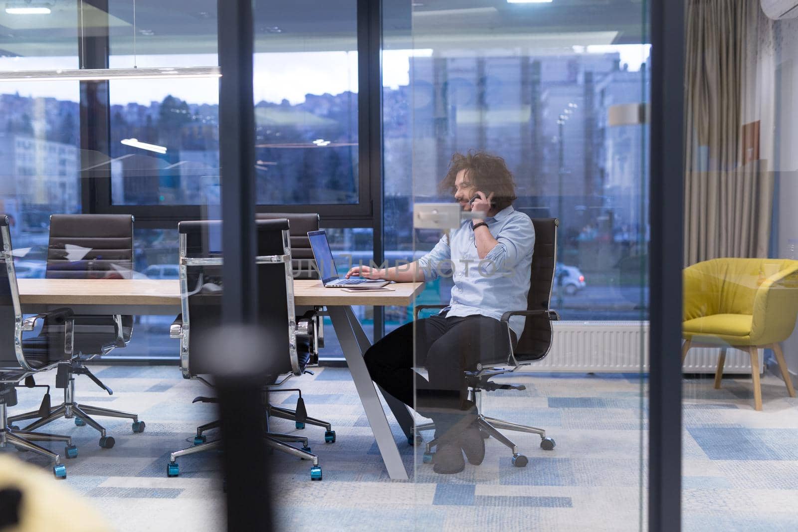 Young casual businessman using smartphone in the startup office