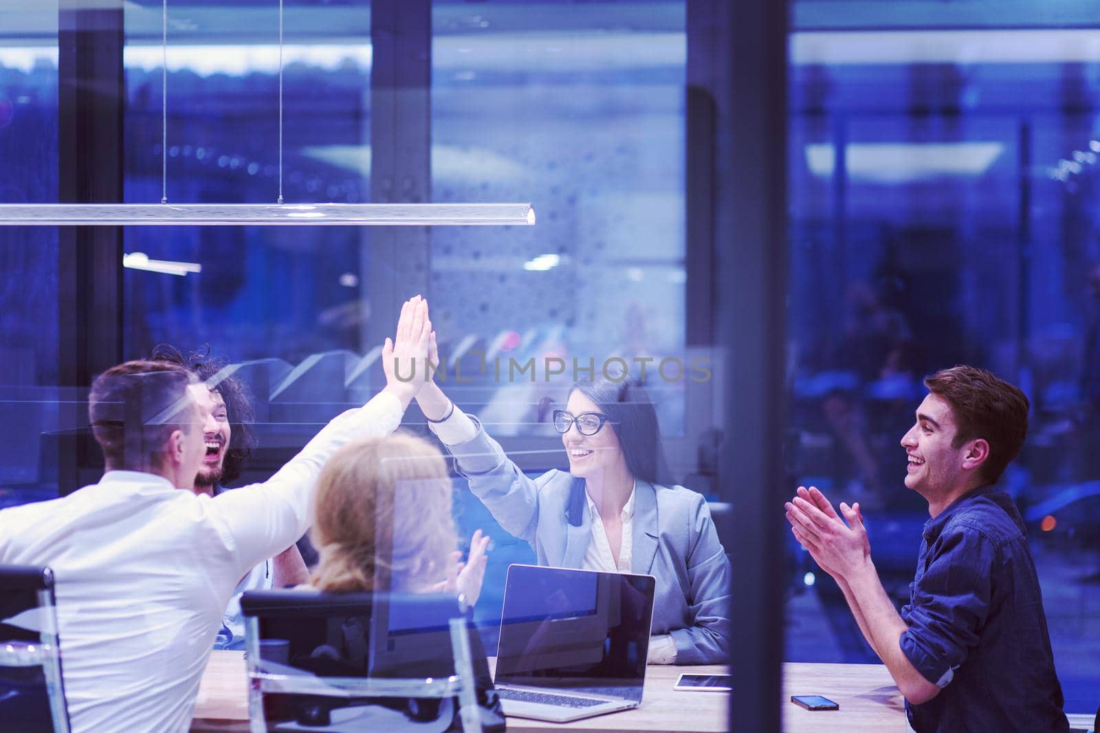 Group of young business people looking happy while celebrating success at their working places in startup office