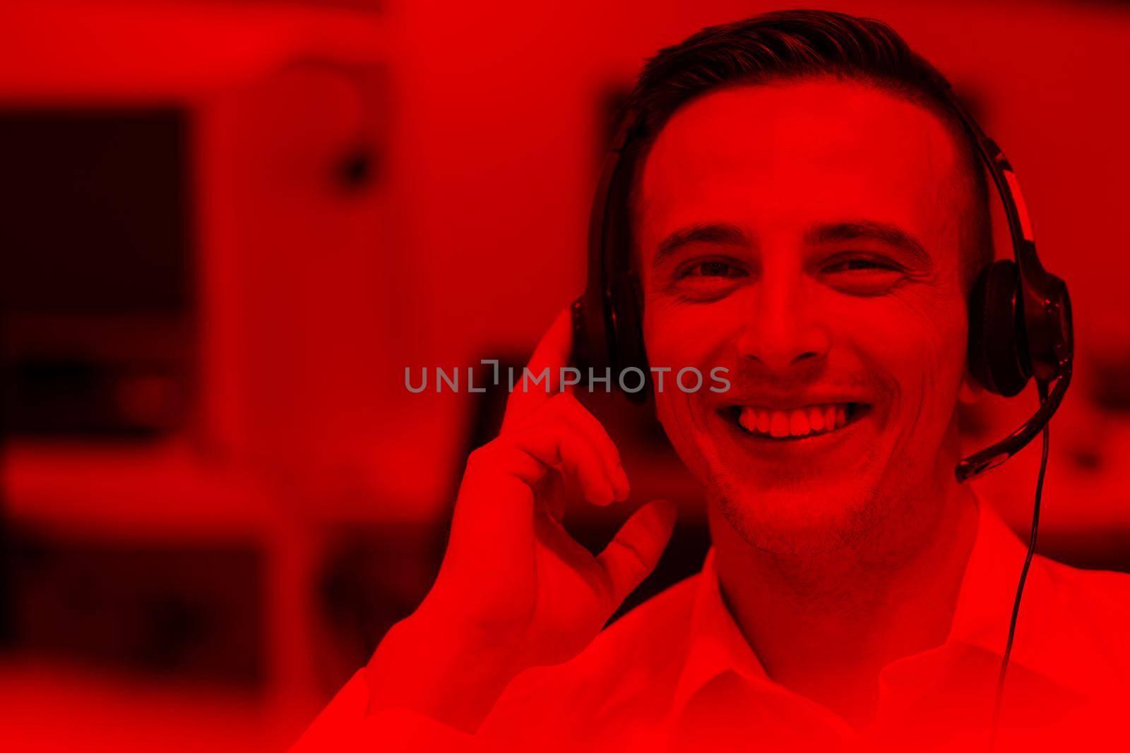 young smiling male call centre operator doing his job with a headset