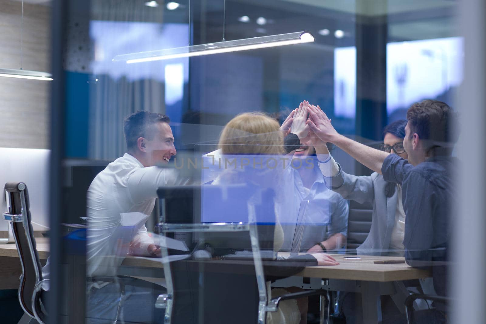 Group of young business people looking happy while celebrating success at their working places in startup office