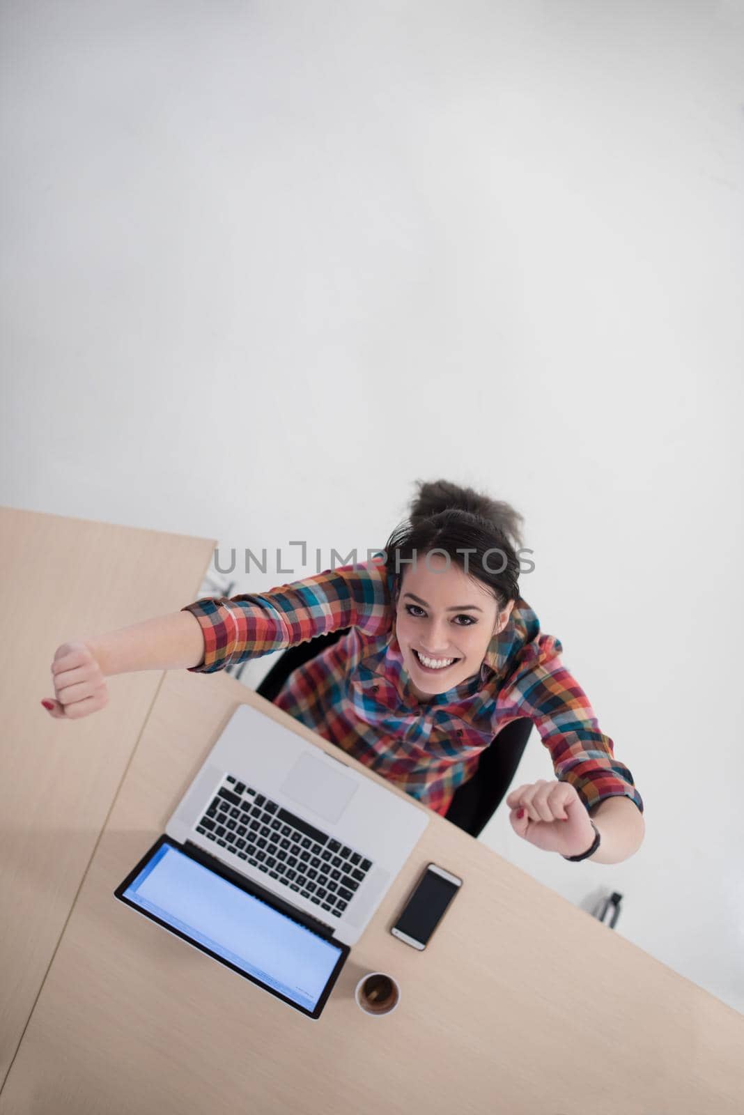 top view of young business woman working on laptop computer in modern bright startup office interior