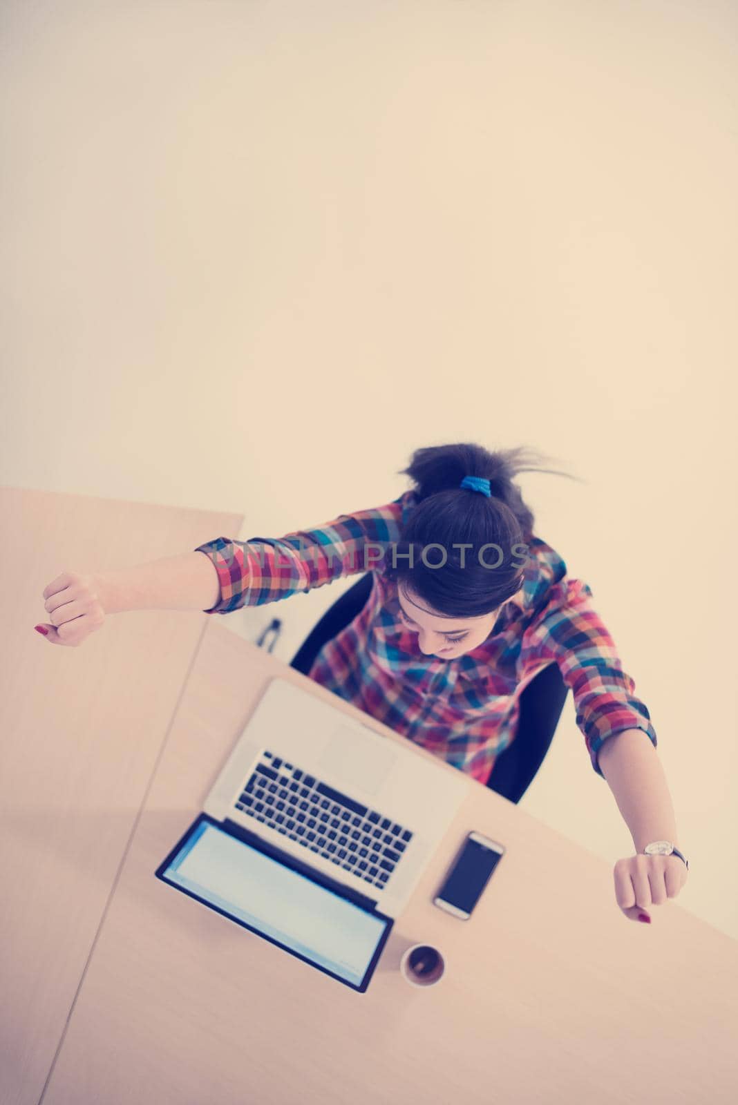 top view of young business woman working on laptop computer in modern bright startup office interior