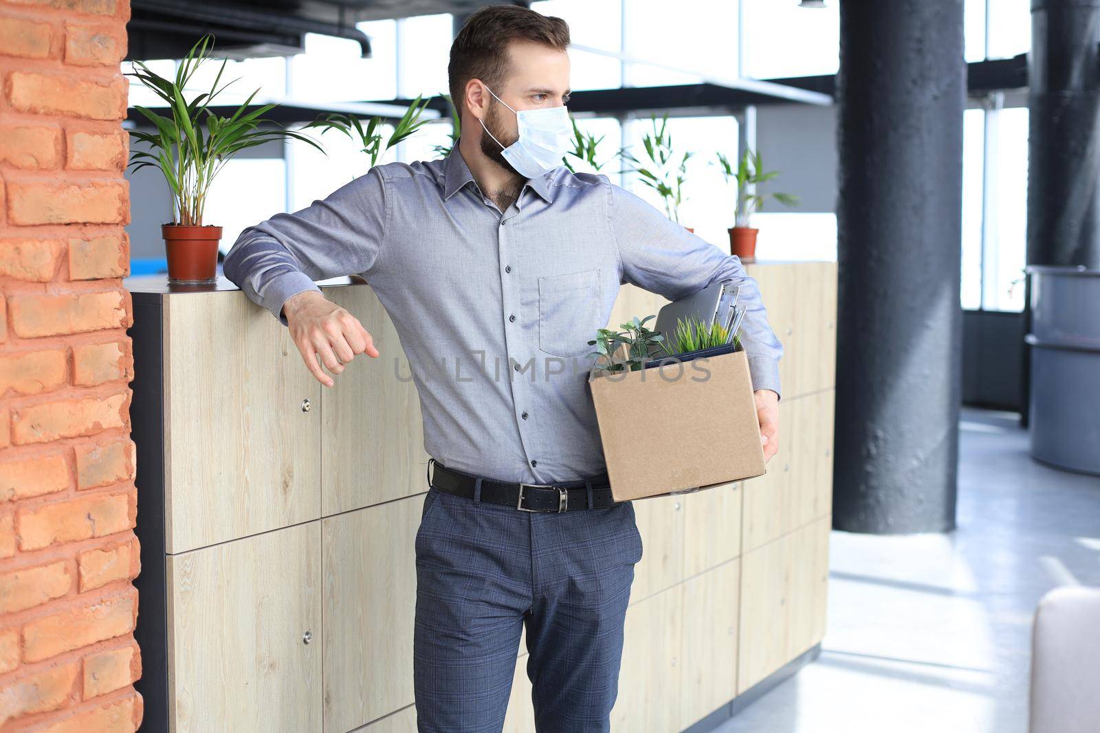 Dismissal employee in an epidemic coronavirus covid-19. Dismissed worker going from the office with his office supplies