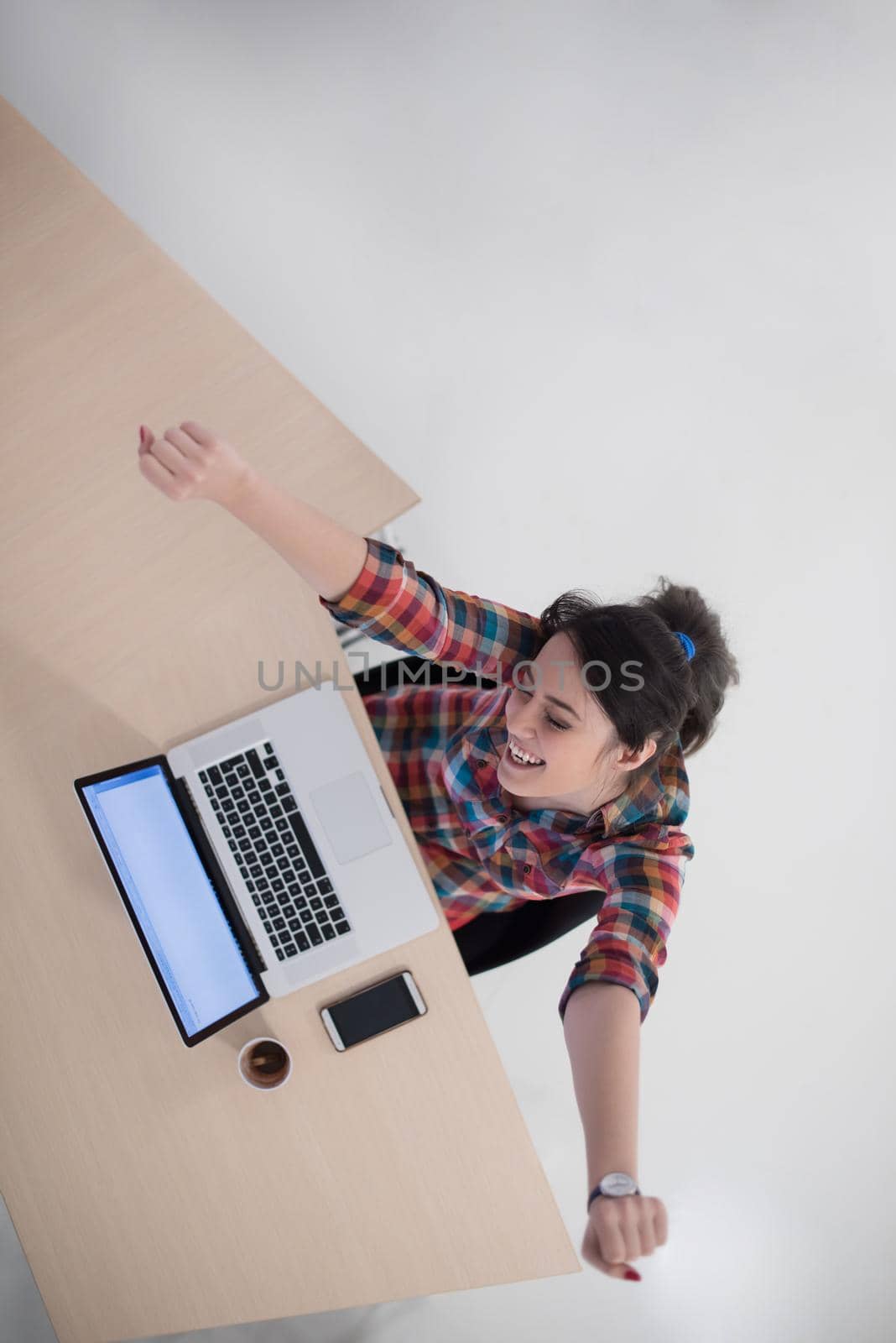 top view of young business woman working on laptop computer in modern bright startup office interior