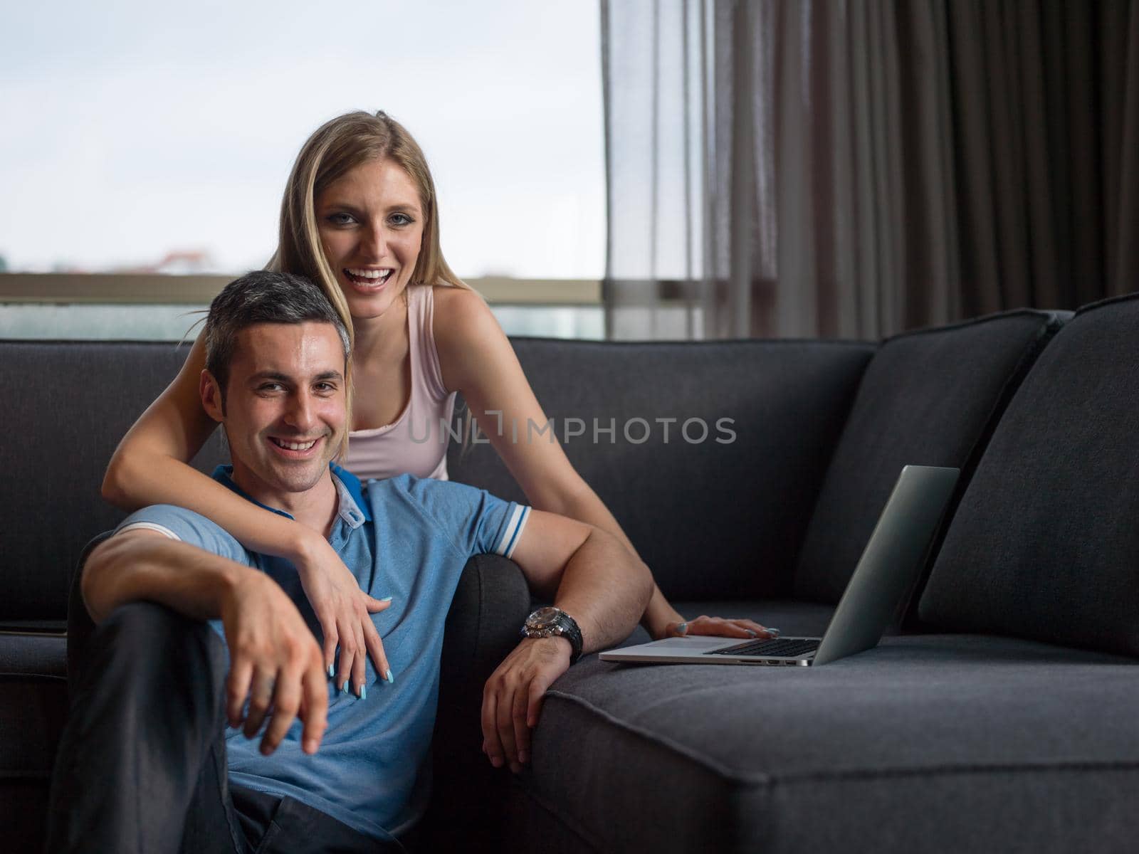 Attractive couple using a laptop in the living room