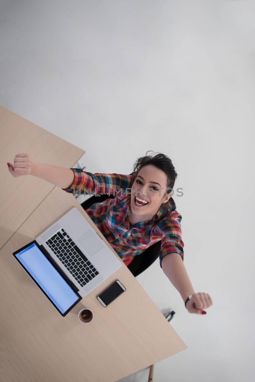 top view of young business woman working on laptop computer in modern bright startup office interior