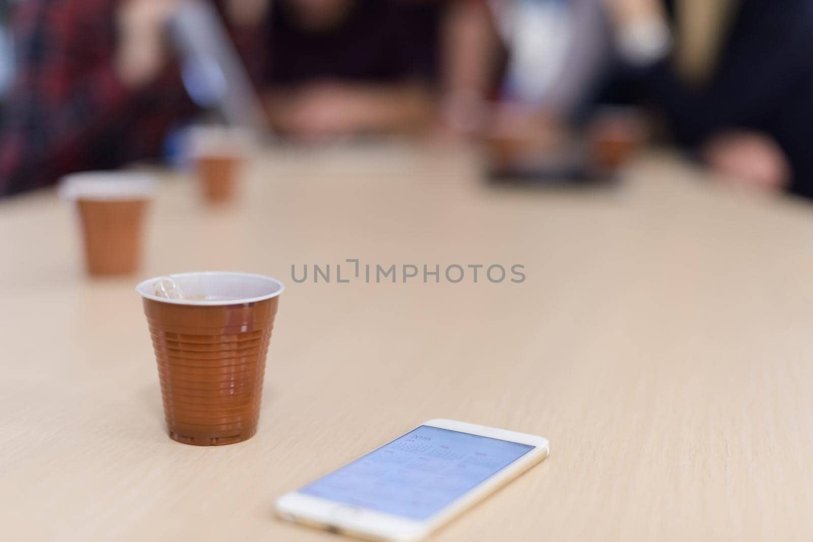 startup business team on meeting in modern bright office interior brainstorming, working on laptop and tablet computer. Smartphone on table in focus