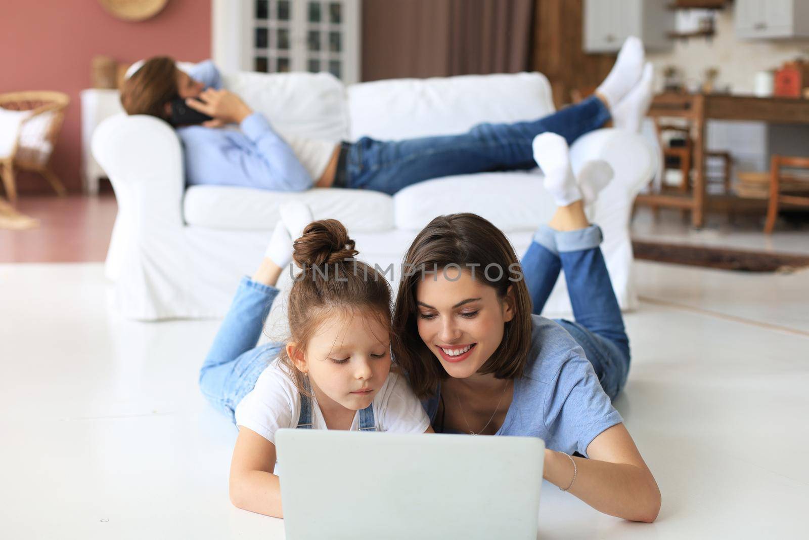 Happy mom and little child girl looking at screen laptop, talking to webcam, chatting online via computer app
