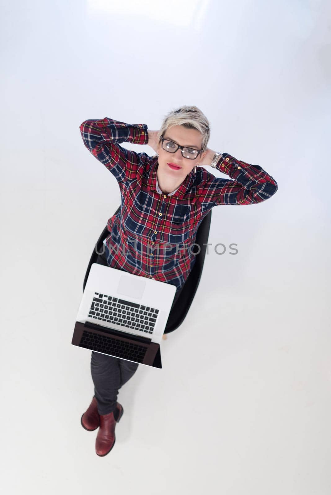 top view of young business woman working on laptop computer in modern bright startup office interior, sitting on floor