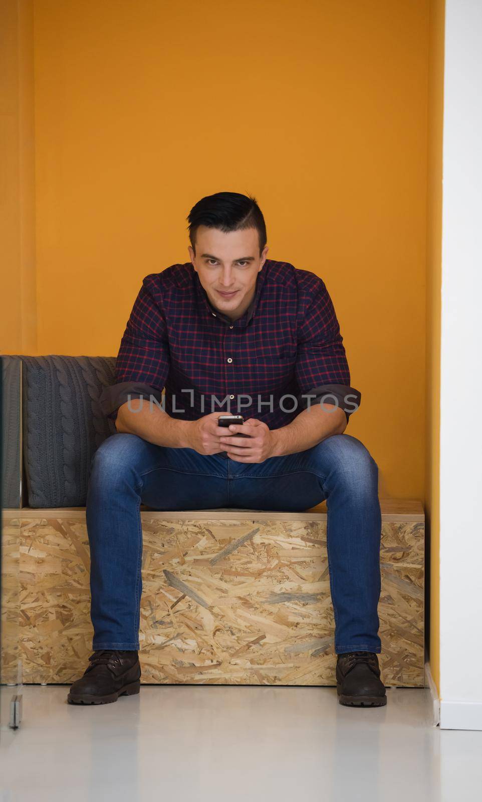 man in crative box working on smart phone by dotshock