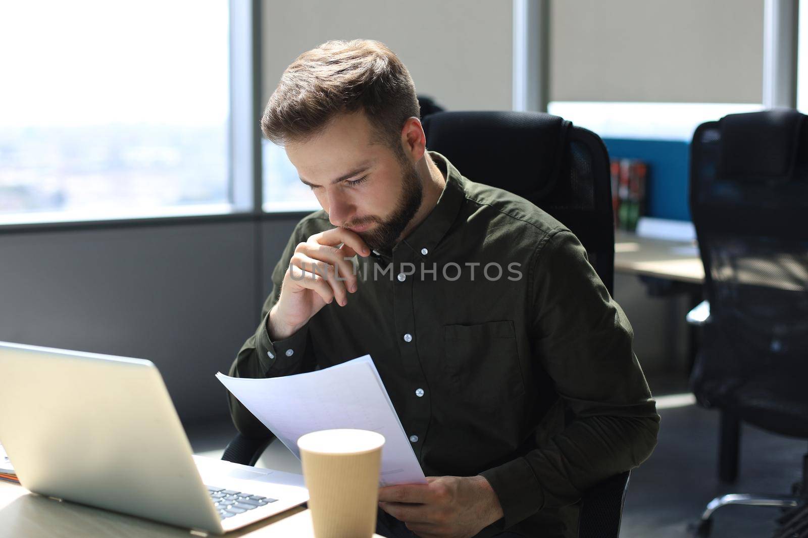 Successful entrepreneur is studying documents with attentive and concentrated look. by tsyhun