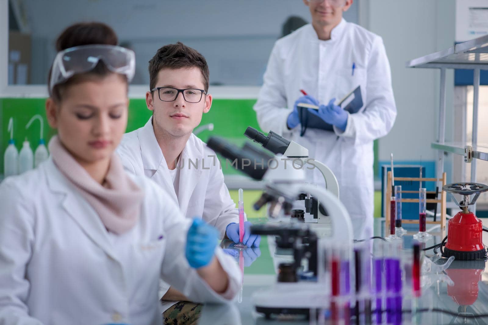 Group of young medical students doing research together in chemistry laboratory,teamwork by college student indoors