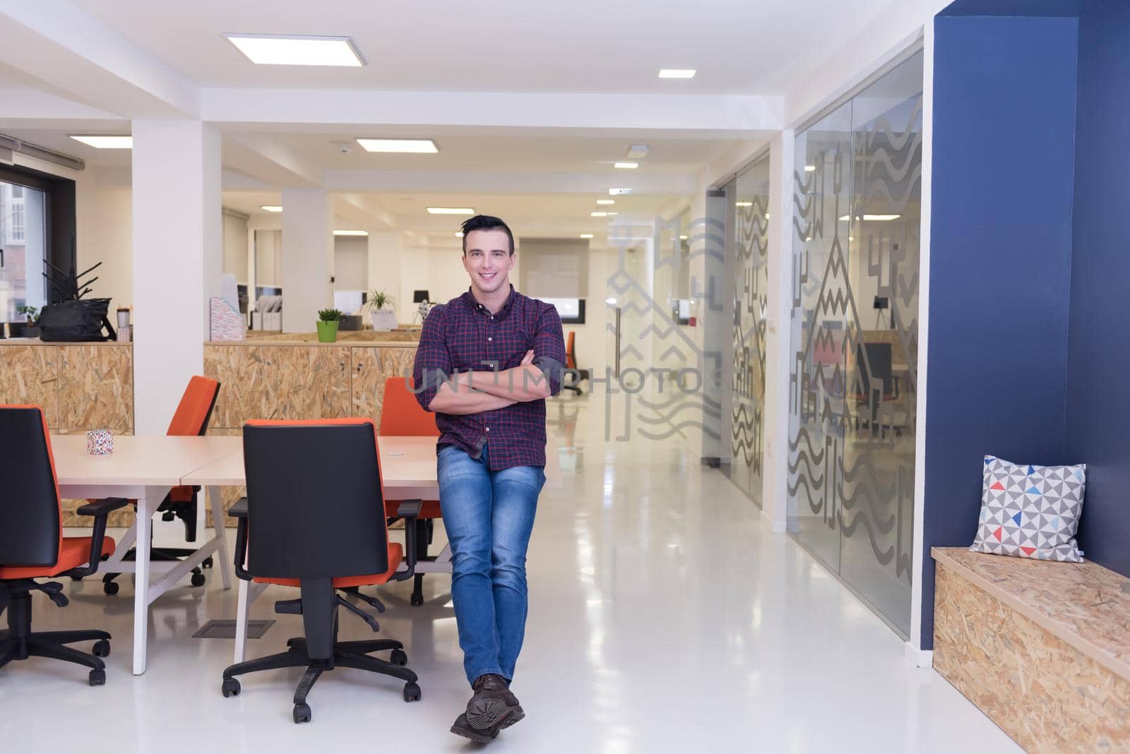 portrait of young business man in casual clothes sitting on table at  new startup office space and working on tablet computer