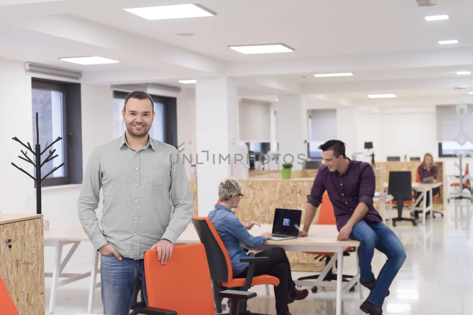 startup business, businessman portrait at modern office, team brainstorming in background by dotshock