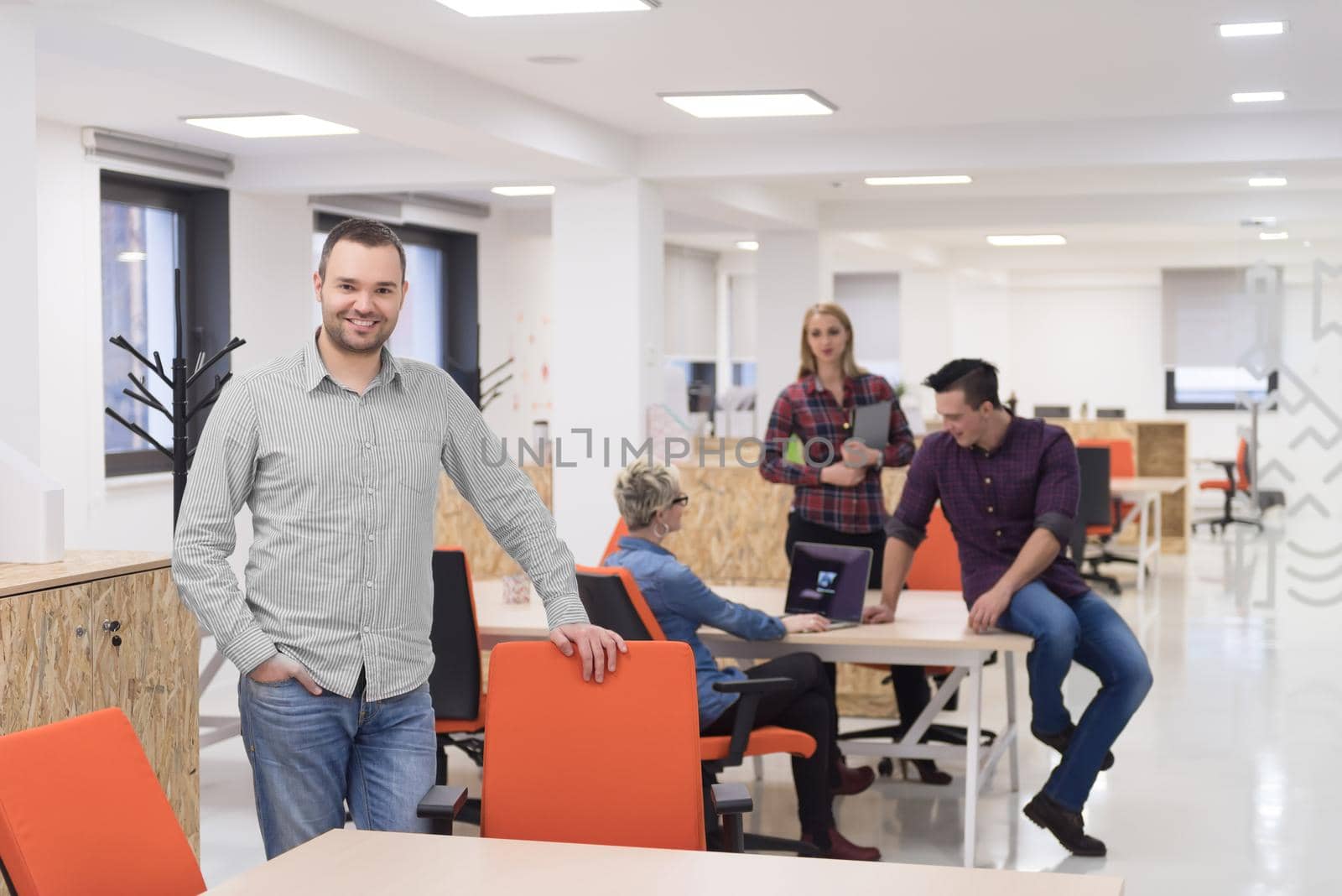 startup business, businessman portrait at modern office, team brainstorming in background by dotshock