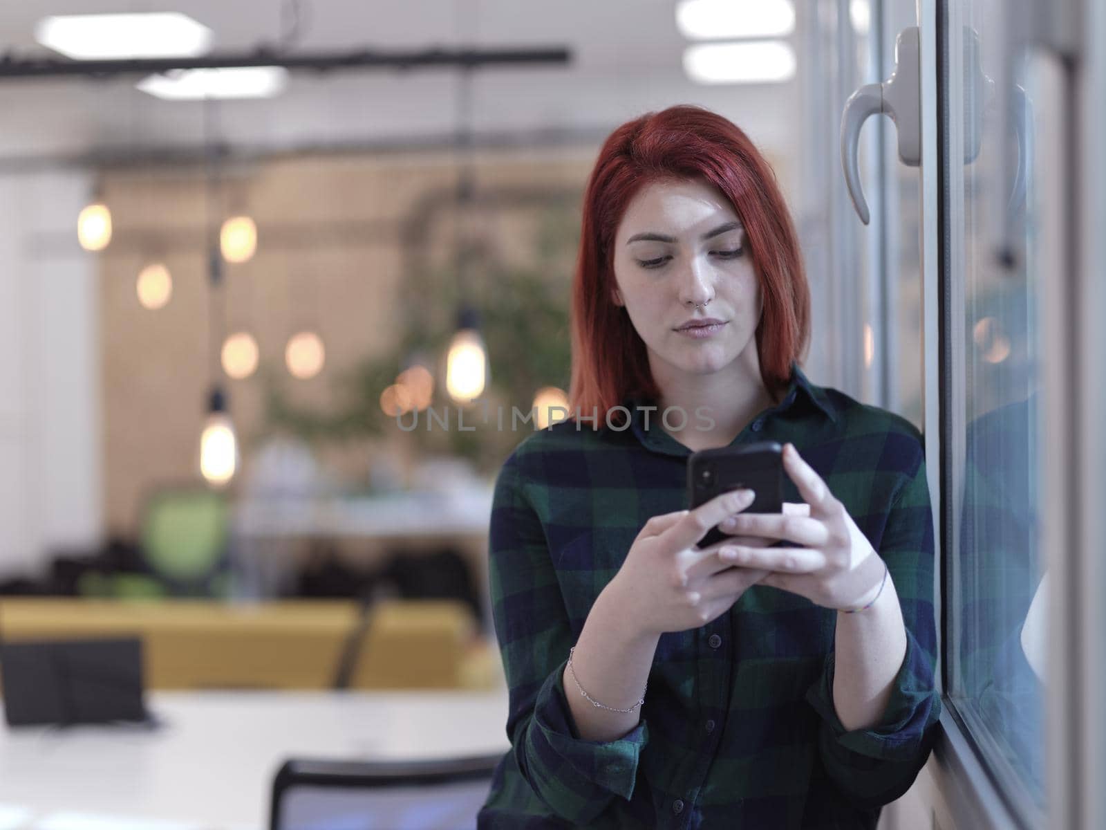 redhead business woman at office using smart phone by dotshock