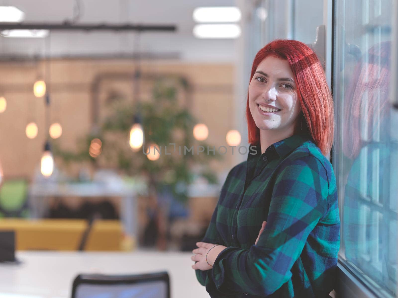 redhead business woman portrait in creative modern coworking startup open space office by dotshock