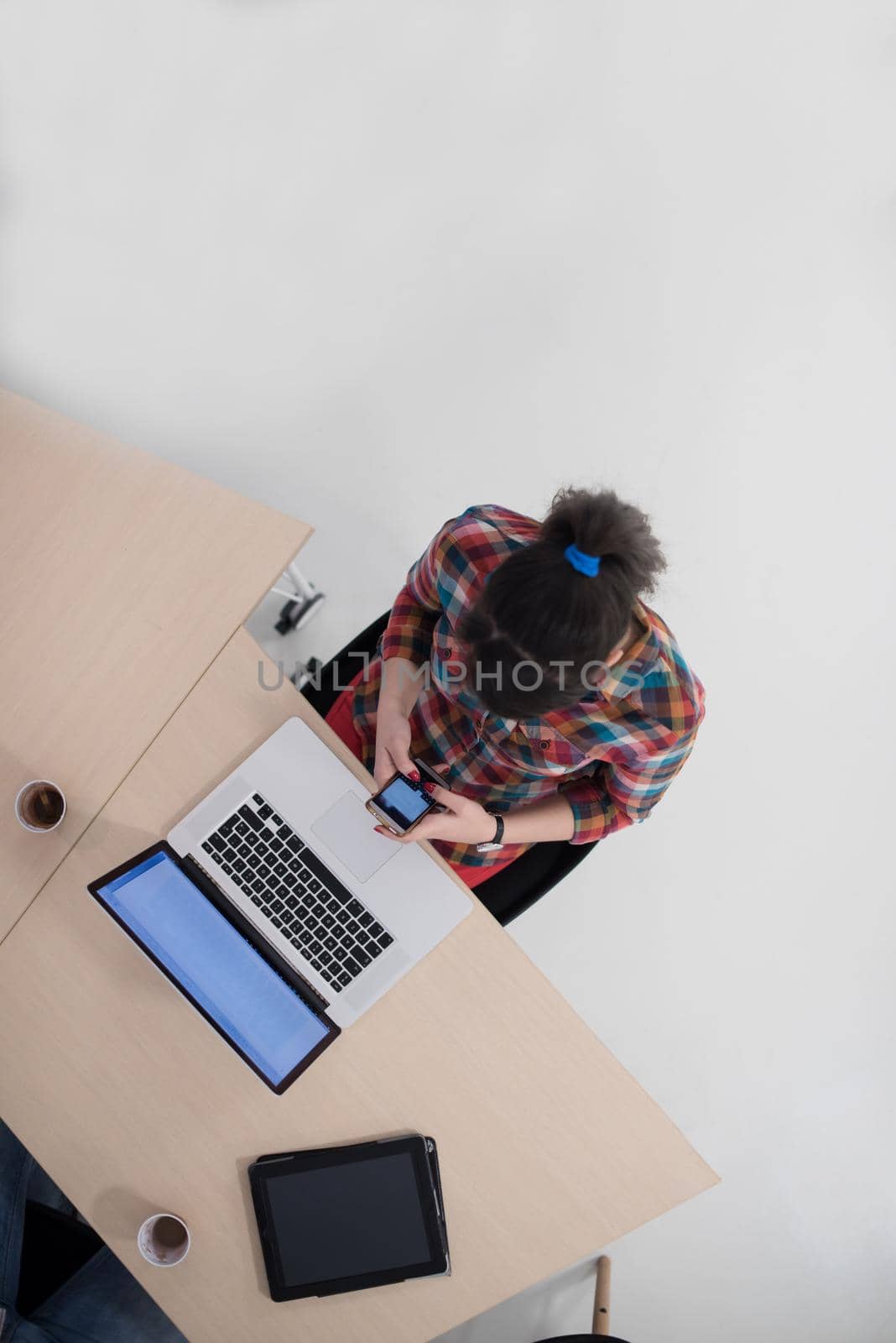 top view of young business woman working on laptop computer in modern bright startup office interior