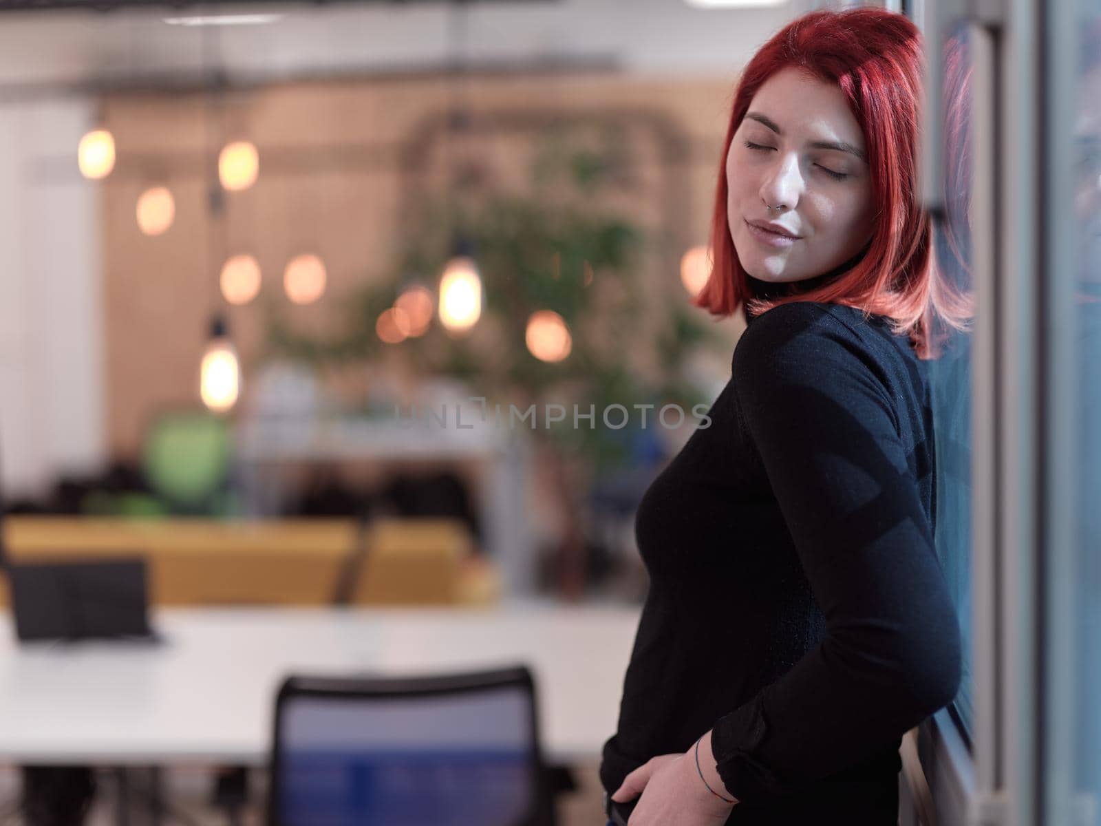 redhead business woman portrait  in creative modern coworking startup open space office by dotshock