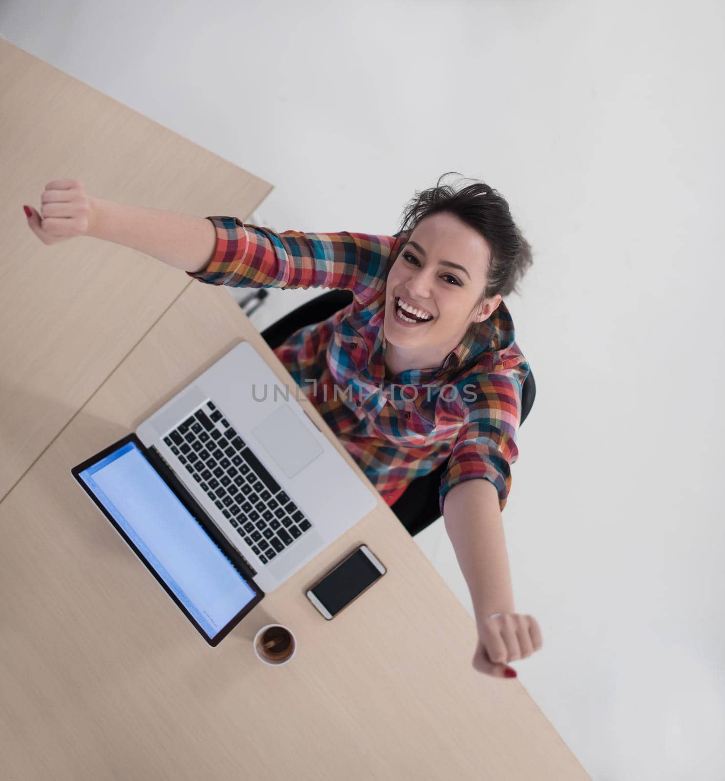 top view of young business woman working on laptop computer in modern bright startup office interior