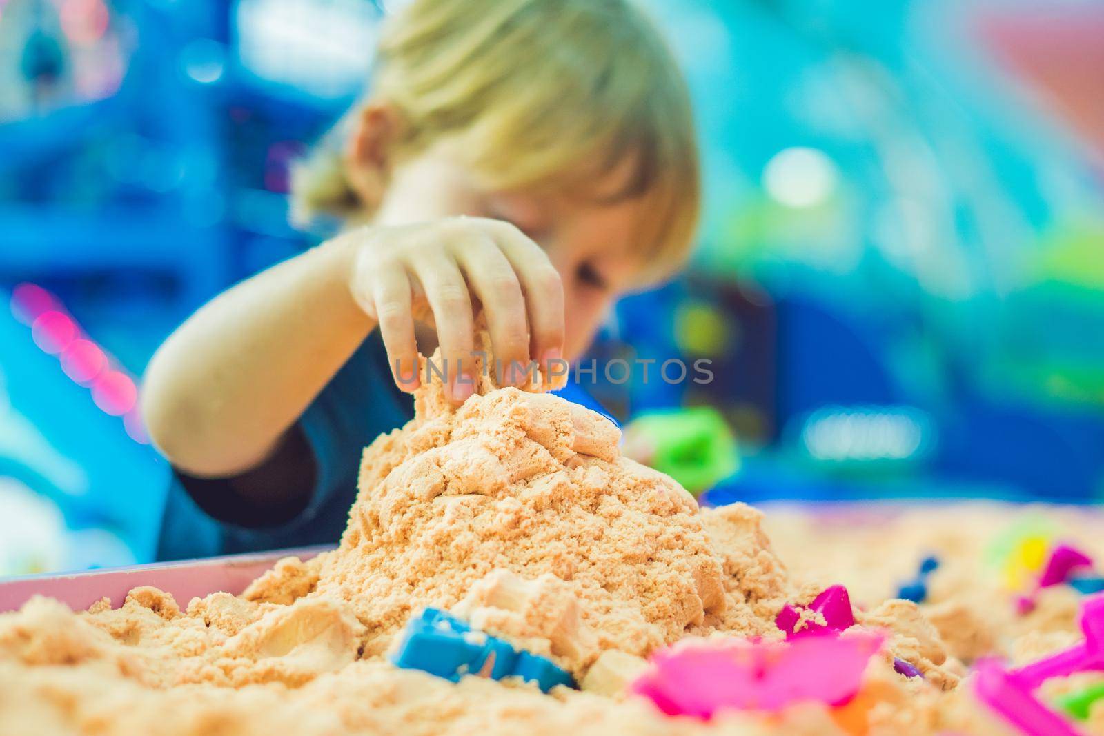 Boy playing with kinetic sand in preschool. The development of fine motor concept. Creativity Game concept.