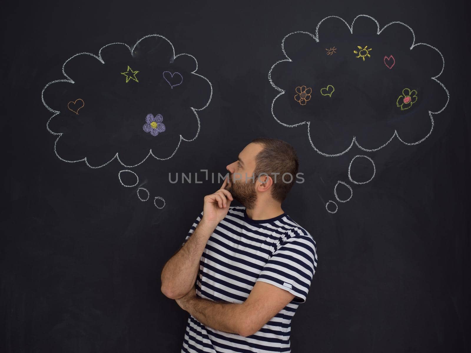 young future father thinking about names for his unborn baby to writing them on a black chalkboard