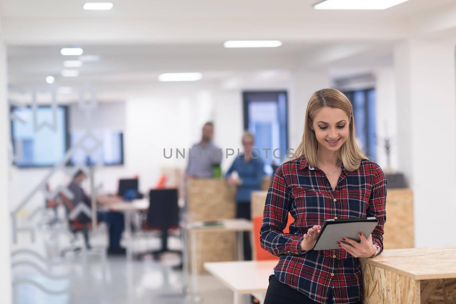 portrait of young business woman at modern startup office interior, team in meeting in background