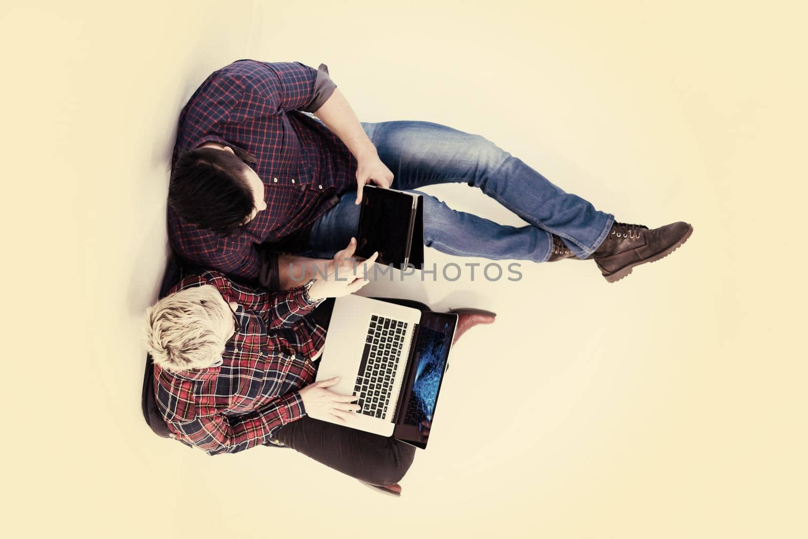 top view of  couple working on laptop computer at startup office by dotshock