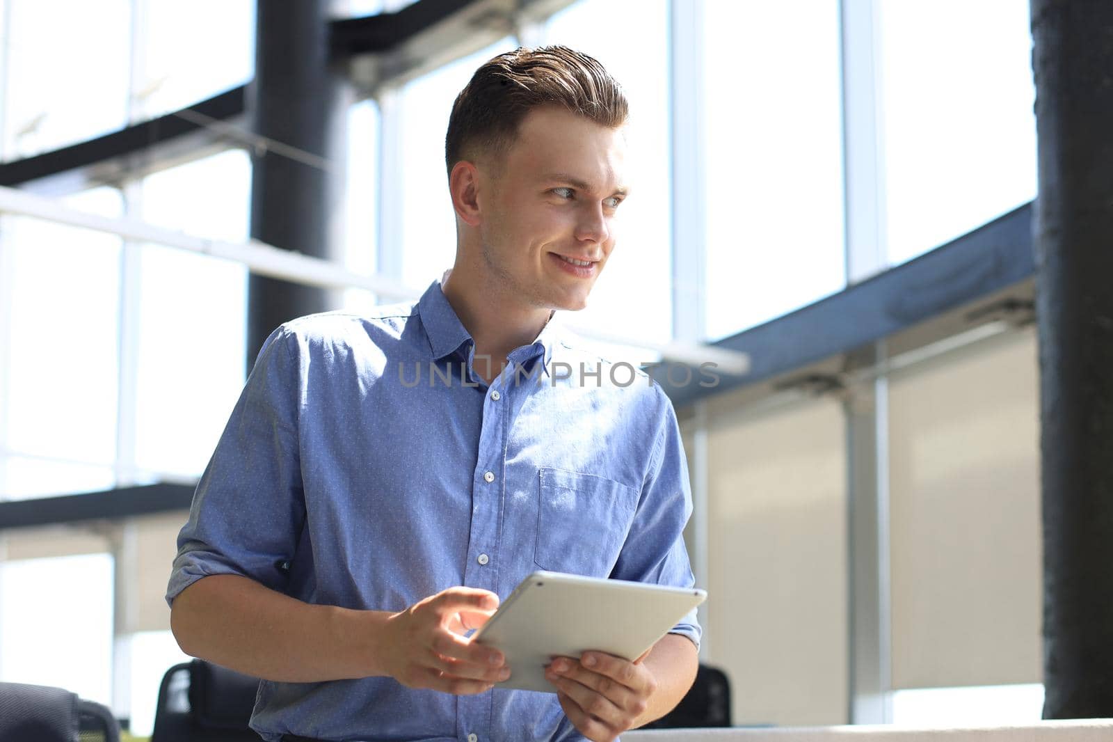 Young businessman using his tablet in the office