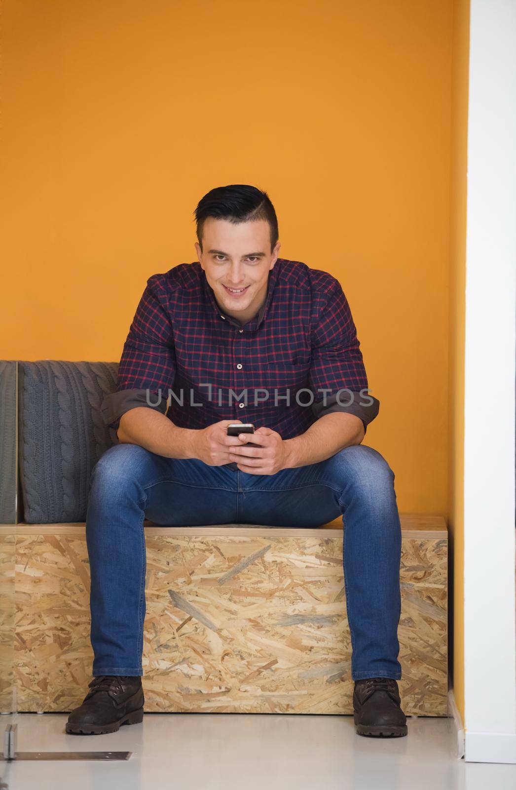 young man in crative box working on smart phone, startup business modern office room  interior