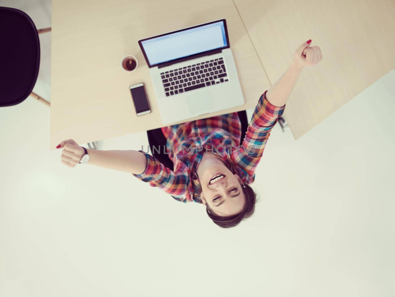 top view of young business woman working on laptop computer in modern bright startup office interior