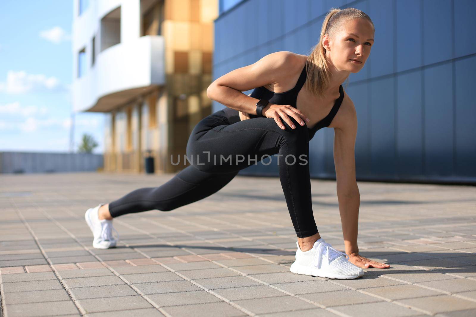 Athletic woman in sports clothing standing on the start line while running outdoors. by tsyhun
