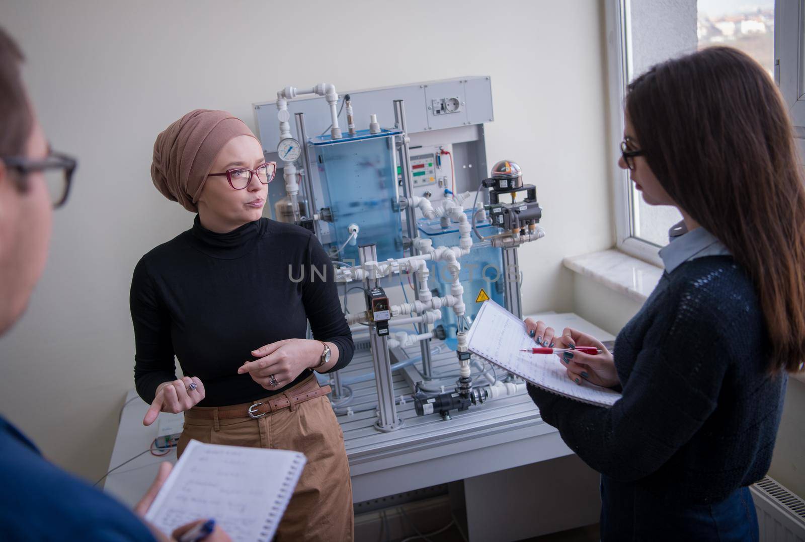 Group of students doing technical vocational practice with young female muslim teacher in the electronic classroom, Education and technology concept